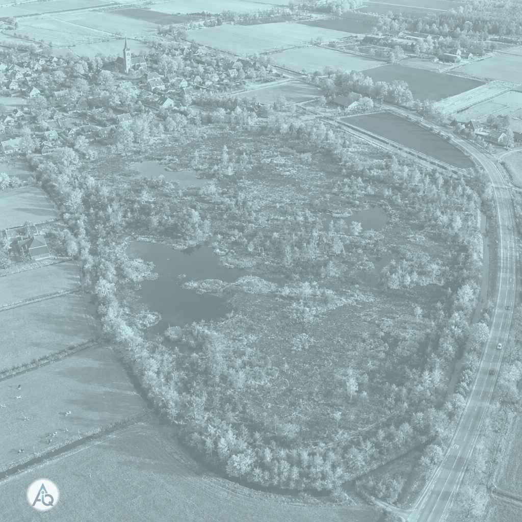 Luchtfoto van een klein veengebied omringd door akkers, een dorp en wegen