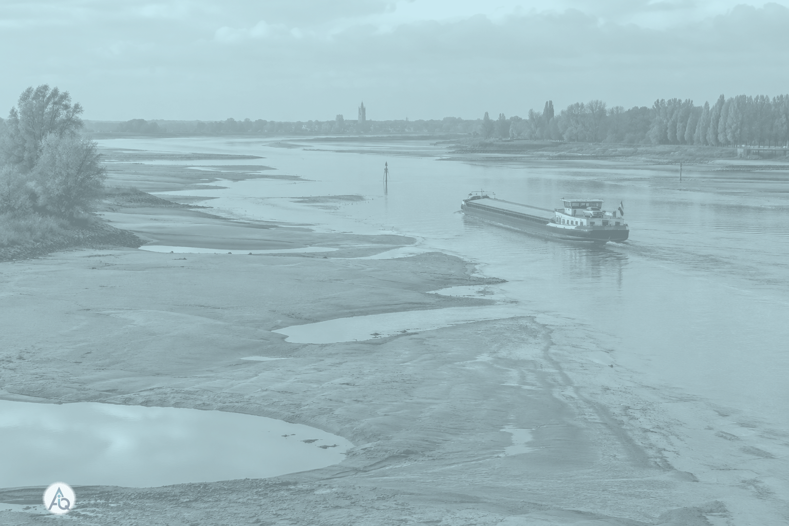 De Rijn bij laagwater: blootgevallen zandbanken en een smalle vaargeul voor een vrachtschip
